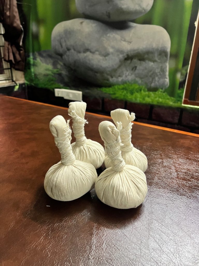 Ayurvedic Therapy Potli Set on Teakwood Surface